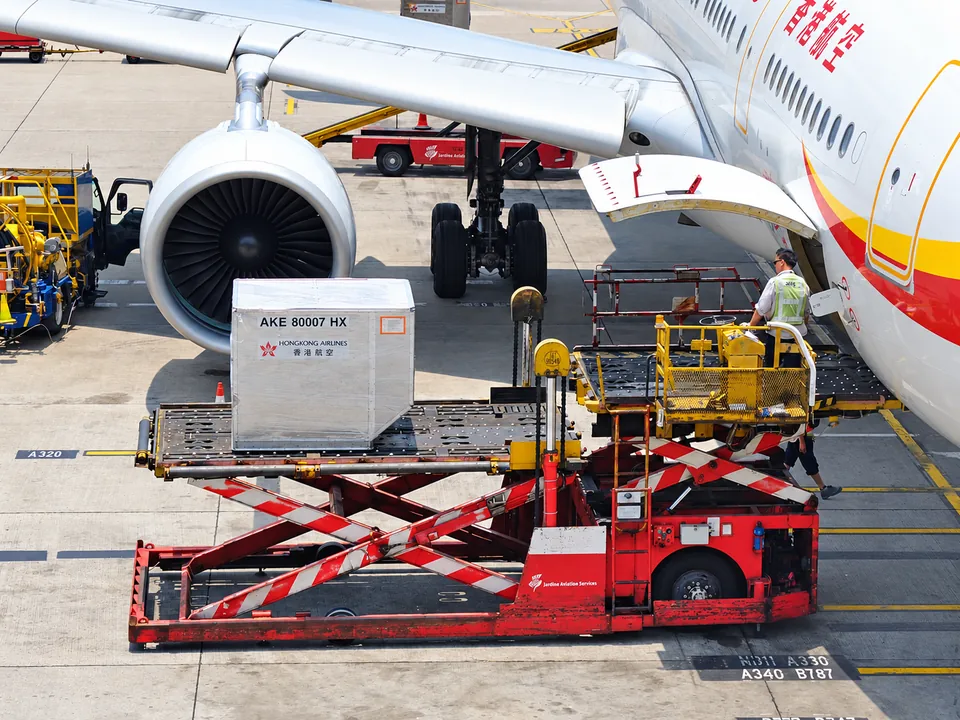 Aircraft cargo container on a raised loading platform beside an aircraft